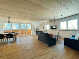 费尔德伯格Haus Wiesenquelle, Deluxe-Apartment 'Feld & Berg'的客厅设有木制天花板和桌椅