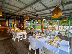 Kaoh SdachKoh Sdach Resort的餐厅配有白色的桌椅和灯光