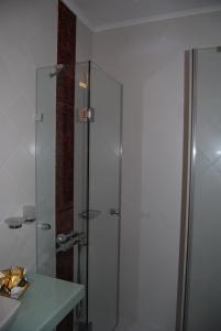卡斯托里亚Room "honeybee" in a neoclassical house的一间带玻璃淋浴和水槽的浴室