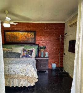 德班Ladybird的一间卧室设有一张床和砖墙