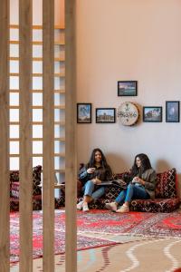 吉达ibis Jeddah City Center的两个女人坐在房间里沙发上