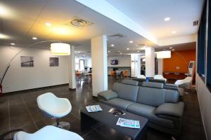 朗吉斯All Suites Appart Hôtel Aéroport Paris Orly – Rungis的客厅配有沙发和桌椅
