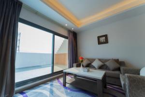 利雅德Riyadha Home Apartment的带沙发和大窗户的客厅