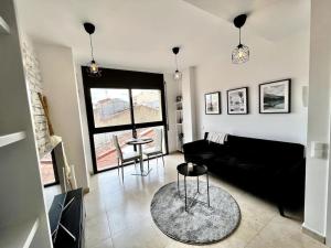 特拉萨Acogedor apartamento entero的客厅配有黑色沙发和桌子
