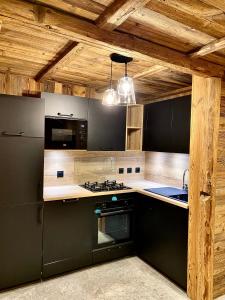 贝桑Chalet Les Cocales Résidence Séjour et nuitées B&B - Appartement Pin Cembro的厨房配有炉灶和炉灶。 顶部烤箱