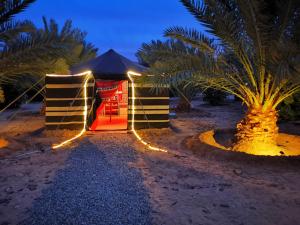 欧拉Almazham camp resort的海滩上的一个夜晚带灯光的帐篷
