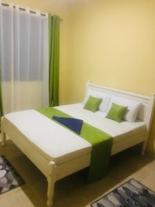 姆特瓦帕Hyven's Apartments的一间卧室配有带绿色和白色枕头的床