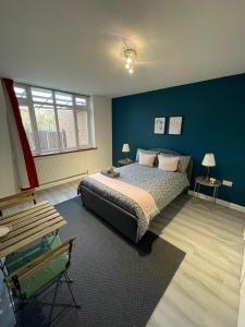 伦敦Willesden Green ROOMS的一间卧室设有一张床和蓝色的墙壁