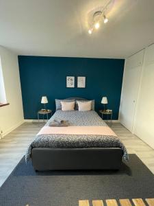 伦敦Willesden Green ROOMS的一间卧室设有一张蓝色墙壁的大床