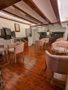 瓦伦西亚Catalina Suites的一间设有粉红色椅子和桌子的等候室