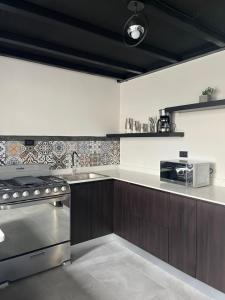 克萨尔特南戈Apartamento en Condominio Privado的厨房配有水槽和炉灶