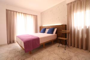 洛斯马蒂雷斯204 I Posada del Mar I Encantador hostel en la playa de Gandia的一间卧室配有一张带蓝色枕头的床和一扇窗户。