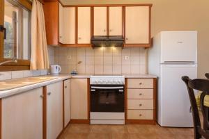 阿凯松Venetico Beachfront Apartments & Suites - 2 Bedroom Sea View Suite的厨房配有炉灶和冰箱。