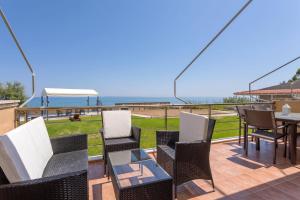 阿凯松Venetico Beachfront Apartments & Suites - 2 Bedroom Sea View Suite的一个带桌椅的海景庭院