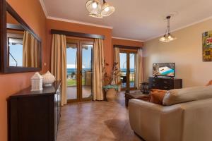 阿凯松Venetico Beachfront Apartments & Suites - 2 Bedroom Sea View Suite的带沙发的客厅,享有海景