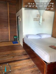 Muang KhôngPa Kha Guesthouse的铺有木地板的客房中的一张床位