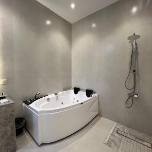 塔伊夫اكواخ سنتارا الريفيه的带淋浴的浴室配有白色浴缸。