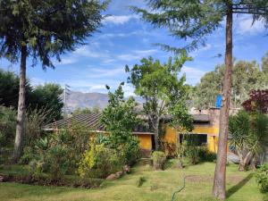 Los Baños del IncaKinti Wasi Casa de Campo的一座带花园和树木的房子