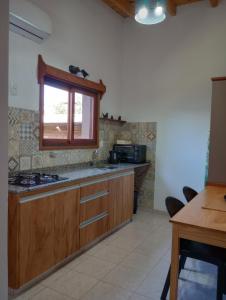 埃尔多拉多Eldorado Apart的厨房配有木制橱柜、窗户和桌子