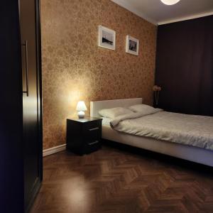 叶尔加瓦Charme apartment的一间卧室配有一张床和一张带台灯的桌子