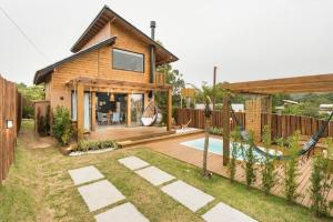 因比图巴Casa com Banheira, Piscina e Quadra de Areia的一个带游泳池后院的房子