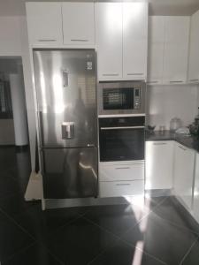 明德卢Cova da Inglesia的厨房配有不锈钢冰箱和白色橱柜