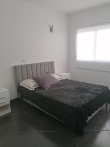 明德卢Cova da Inglesia的白色客房的一张床位,设有窗户