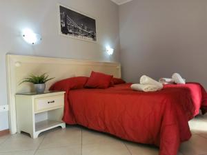 菲乌米奇诺菲乌米奇诺机场旅馆的一间卧室配有两张带红色床单的床和床头柜