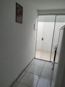 皮涅拉Loft/APTO em Praia da Pinheira的浴室设有玻璃门,铺有瓷砖地板。