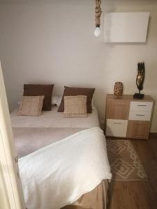 滨海自由城appartement cosy situé à 2mn de la plage à pied climatise的一间卧室配有带白色床单和枕头的床。