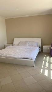 杜拉特阿拉尔Bana Bana Resort的卧室内的一张带白色床单和枕头的床