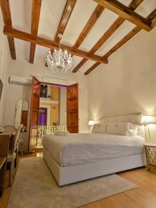 瓦伦西亚Catalina Suites的卧室配有一张白色大床和吊灯。