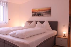 博登斯多夫Appartement Seeleben的一间卧室配有两张带白色枕头的床