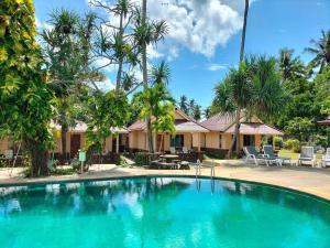 高兰Salatan Resort的棕榈树屋前的游泳池