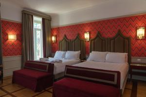 罗马Il Campo Marzio的酒店客房设有两张床和红色的墙壁。