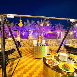 迪拜Desert Safari Dubai Tour Chemist的餐厅顶部一张带食物盘的桌子