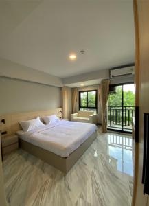 北榄Baan Thanakul Residences的一间卧室配有一张床、一张沙发和窗户。