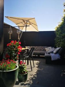 内斯Lanterfant的庭院配有桌椅和遮阳伞。