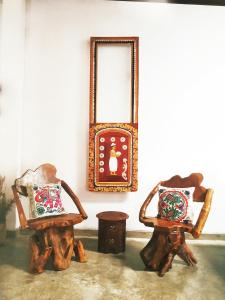 康提Barefoot Inn Kandy的客房内的2把椅子和镜子