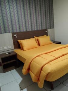 当格浪SMART Dream Inn的一间卧室配有一张带黄色床单的床和一扇窗户。
