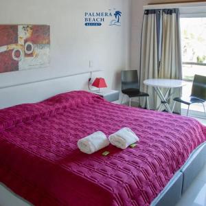 埃斯特角城Palmeras Beach Hotel的一间卧室配有一张大床和两条毛巾