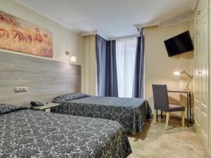 马德里游侠酒店的酒店客房,配有两张床和椅子