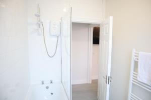 South NorwoodTwelve Thirty Serviced Apartments - 2 Croydon的带淋浴和盥洗盆的白色浴室