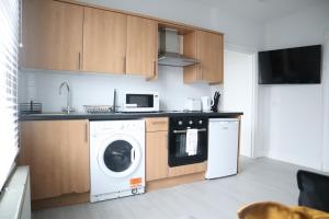 South NorwoodTwelve Thirty Serviced Apartments - 2 Croydon的厨房配有洗衣机和微波炉。