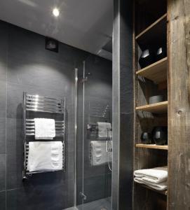 梅杰夫Studio Megève centre的一间带玻璃淋浴间和毛巾的浴室