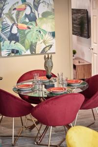 巴拿马城AmazINN Places Rooftop and Design Pool X的一张桌子上摆放着红色的椅子和盘子