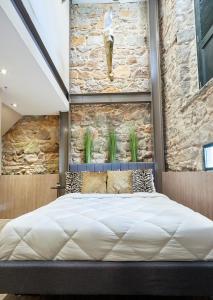 巴拿马城AmazINN Places Rooftop and Design Pool X的一张大床,位于一个石墙房间内