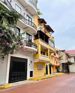 巴拿马城AmazINN Places Casco Viejo Casa Espanola的黄色和白色的建筑,在街上设有阳台