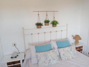 拉坎努塔Barlovento的卧室配有一张墙上有三株植物的床