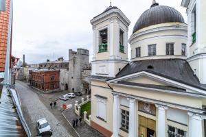 塔林Roofs of the Old Tallinn Guest House的一座建筑的顶部有一个钟楼